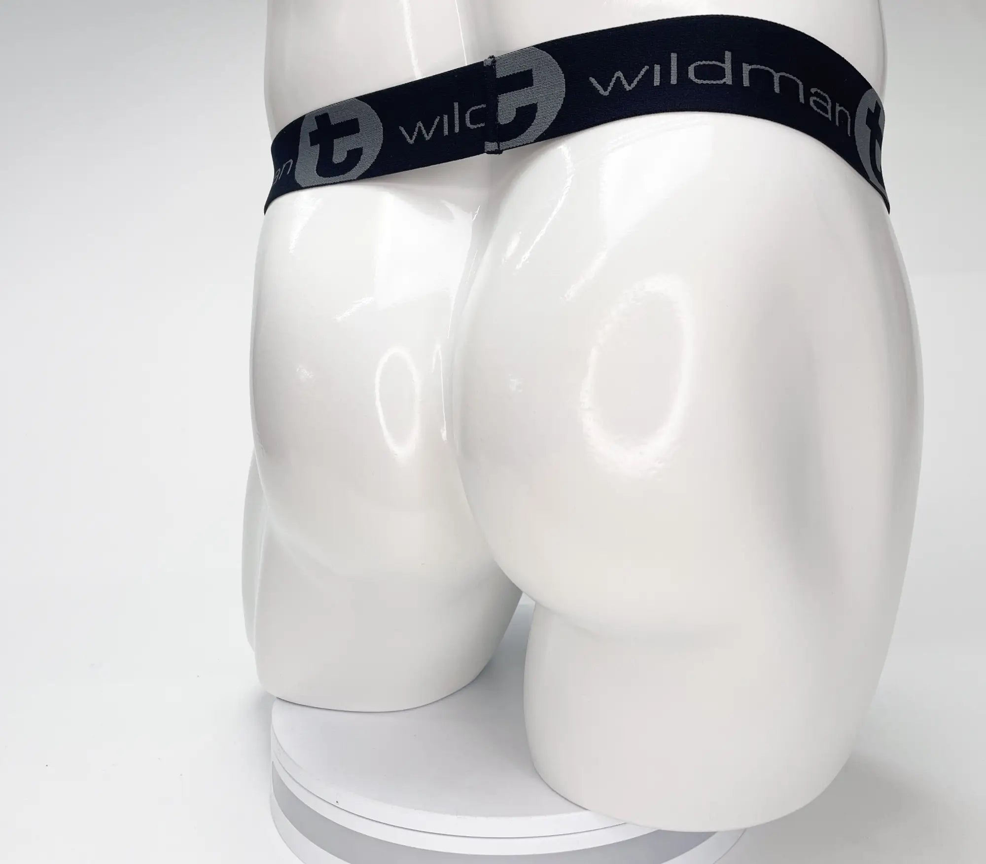Black elastic waistband with wildman branding on a mesh monster cock strapless pouch in black displayed on mannequin