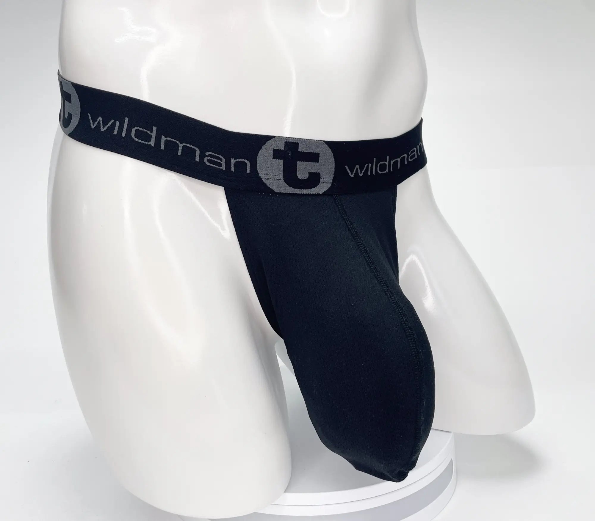 Black wildman brand thong with stretchy elastic waistband featuring gray logo in the wildmant mesh monster cock strapless pouch black