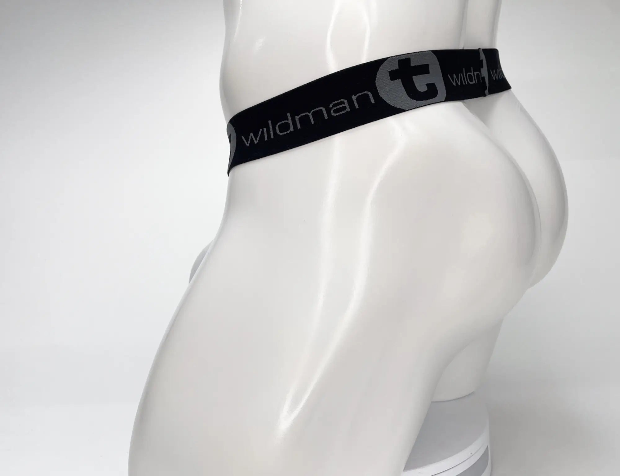 Black elastic waistband with wildman branding and gray t logo on wildmant mesh monster cock strapless pouch white