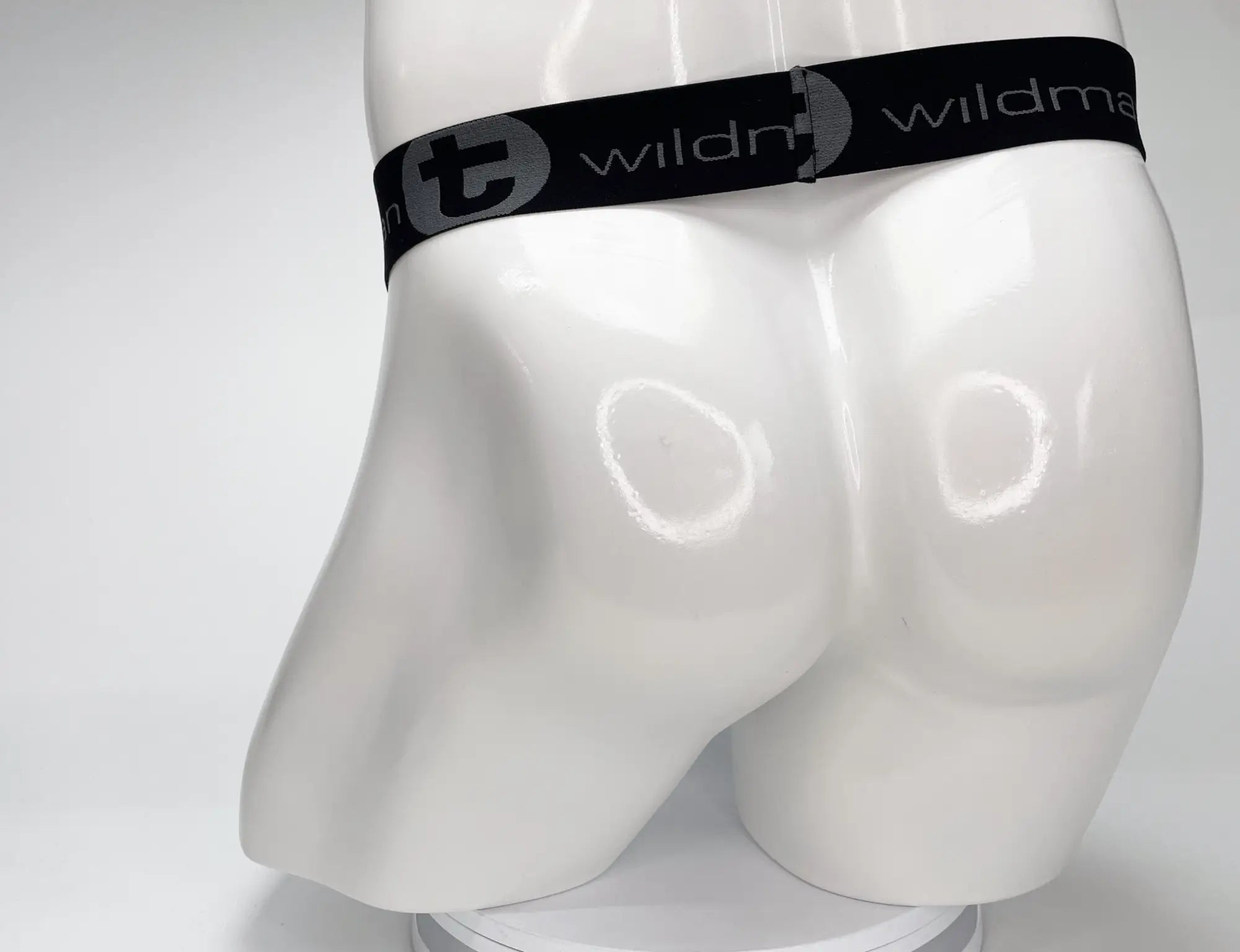WildmanT mesh monster cock strapless pouch white with black elastic waistband and circular wildman logo on white mannequin