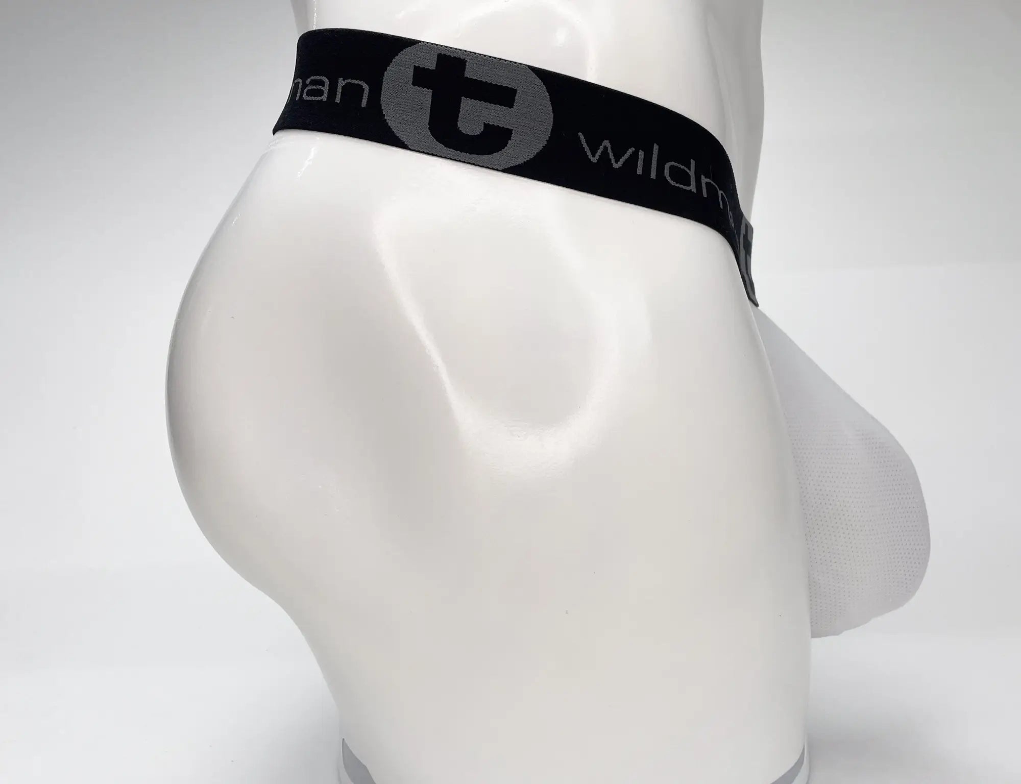 Black elastic waistband with gray wildman logo on white mannequin torso from wildmant mesh monster cock strapless pouch white