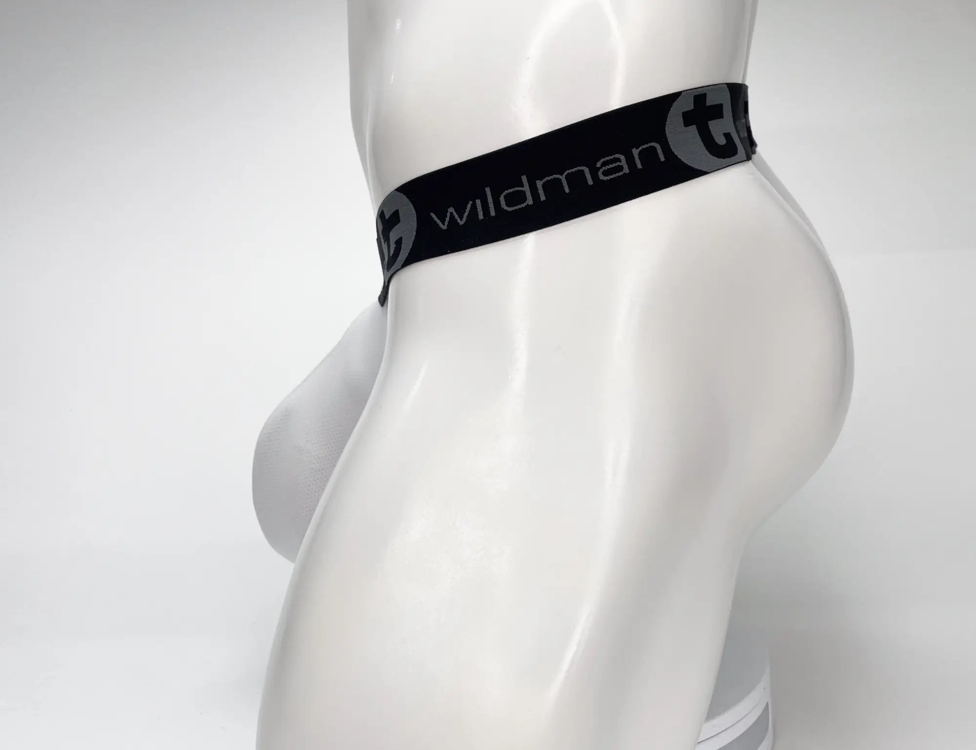 Black elastic waistband with wildman branding and stylized t logo on wildmant mesh monster cock strapless pouch white