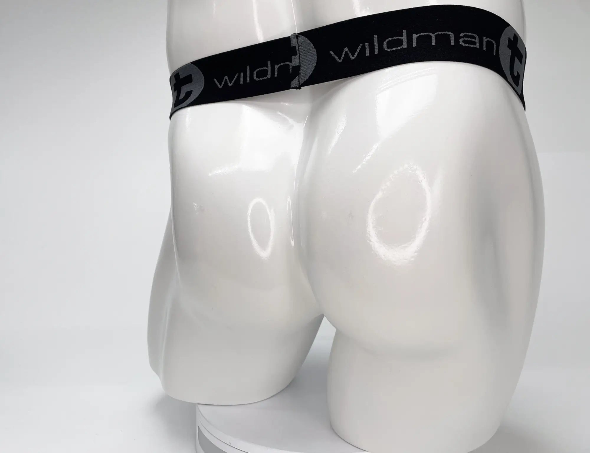 Black elastic waistband with wildman branding in white on the wildmant mesh monster cock strapless pouch white