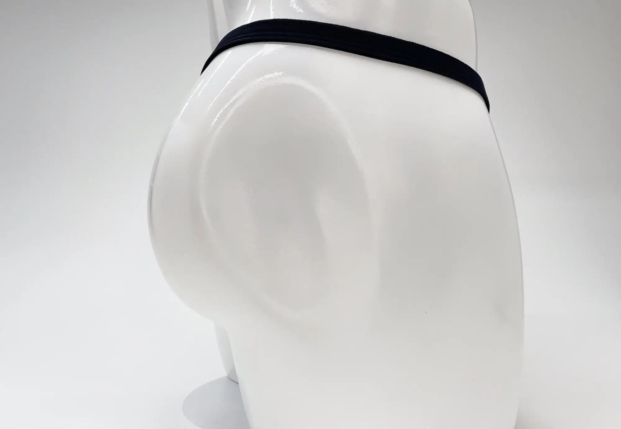Black elastic waistband of wildmant modal micro thong big boy pouch gold on white mannequin front view