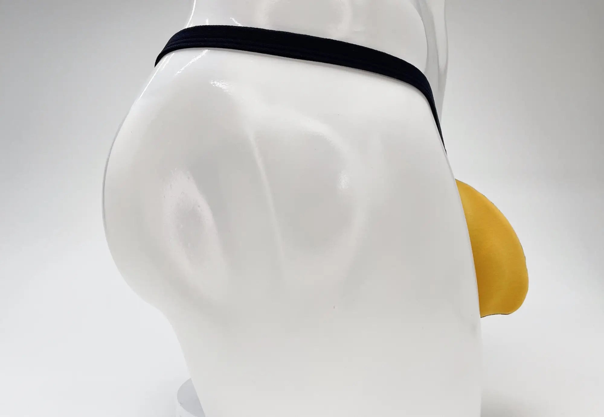 Black elastic waistband with yellow silicone tip on white mannequin for wildmant modal micro thong big boy pouch gold