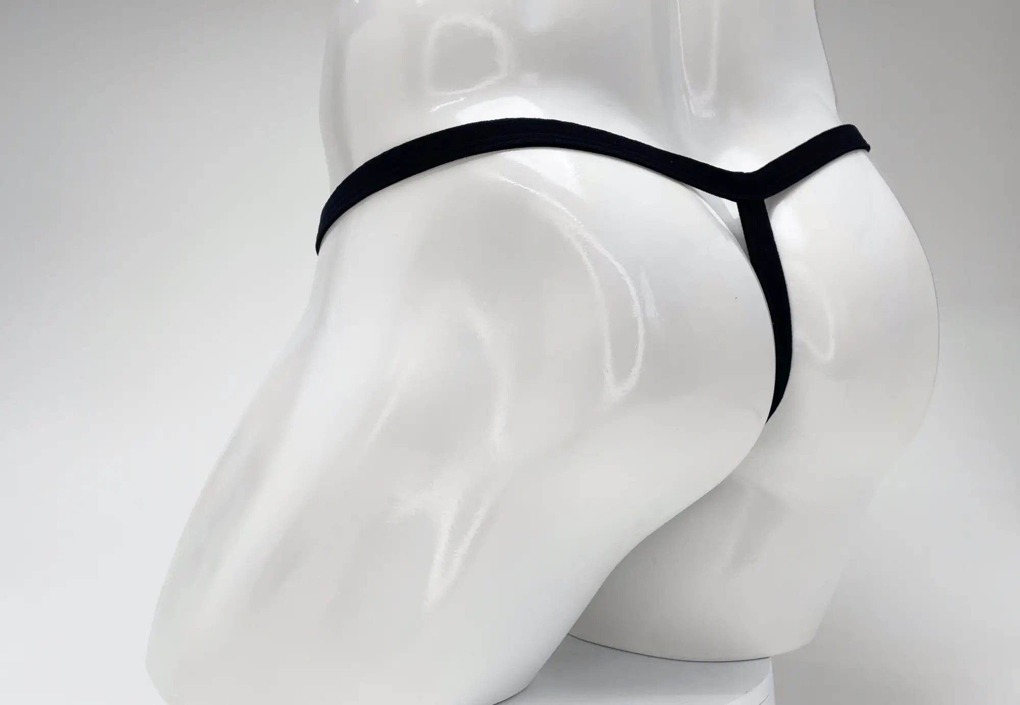 Black thong with a sleek minimalist design made from soft modal fabric featuring the wildmant gold big boy pouch