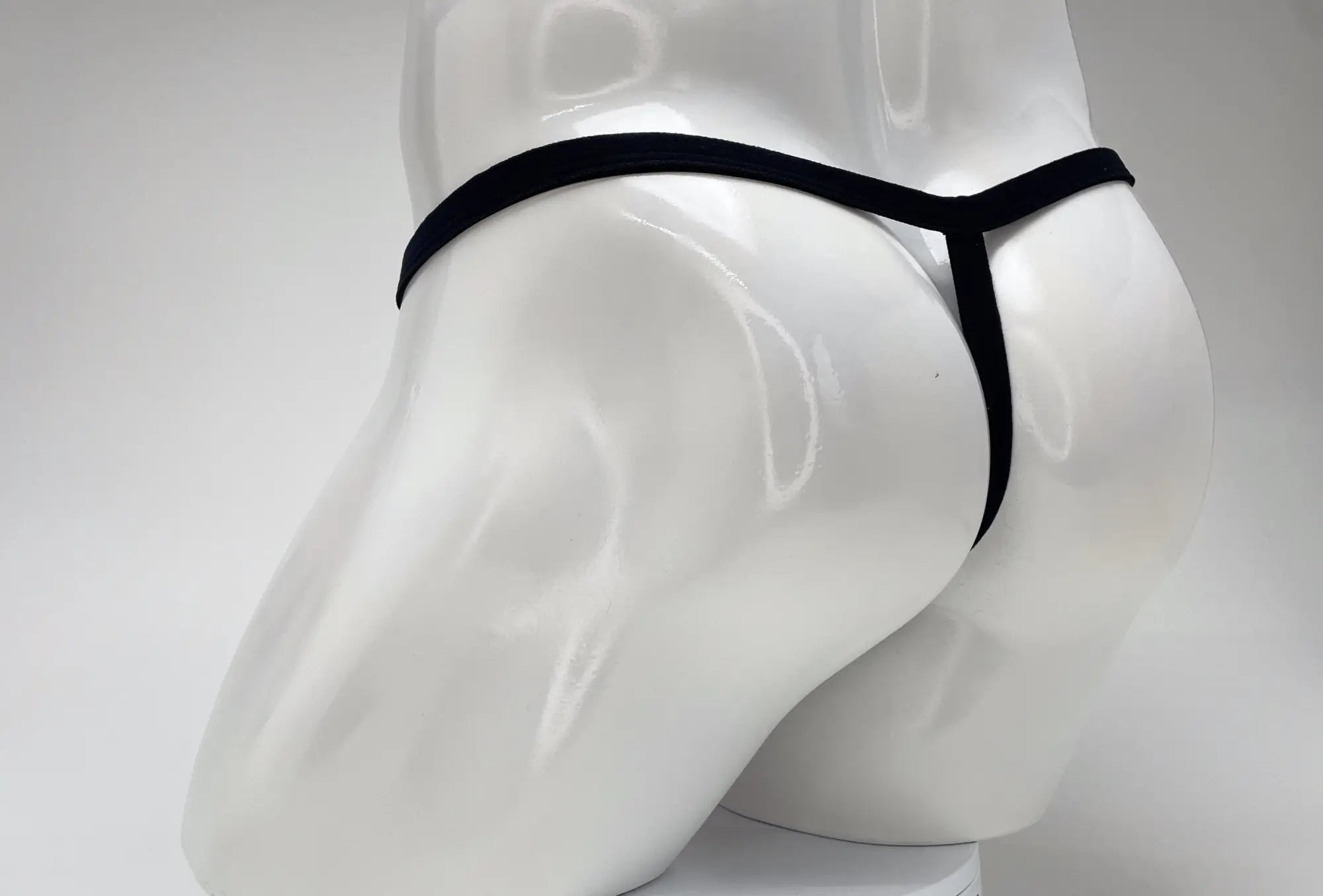 Wildmant modal micro black thong on white mannequin featuring big boy pouch in pink material