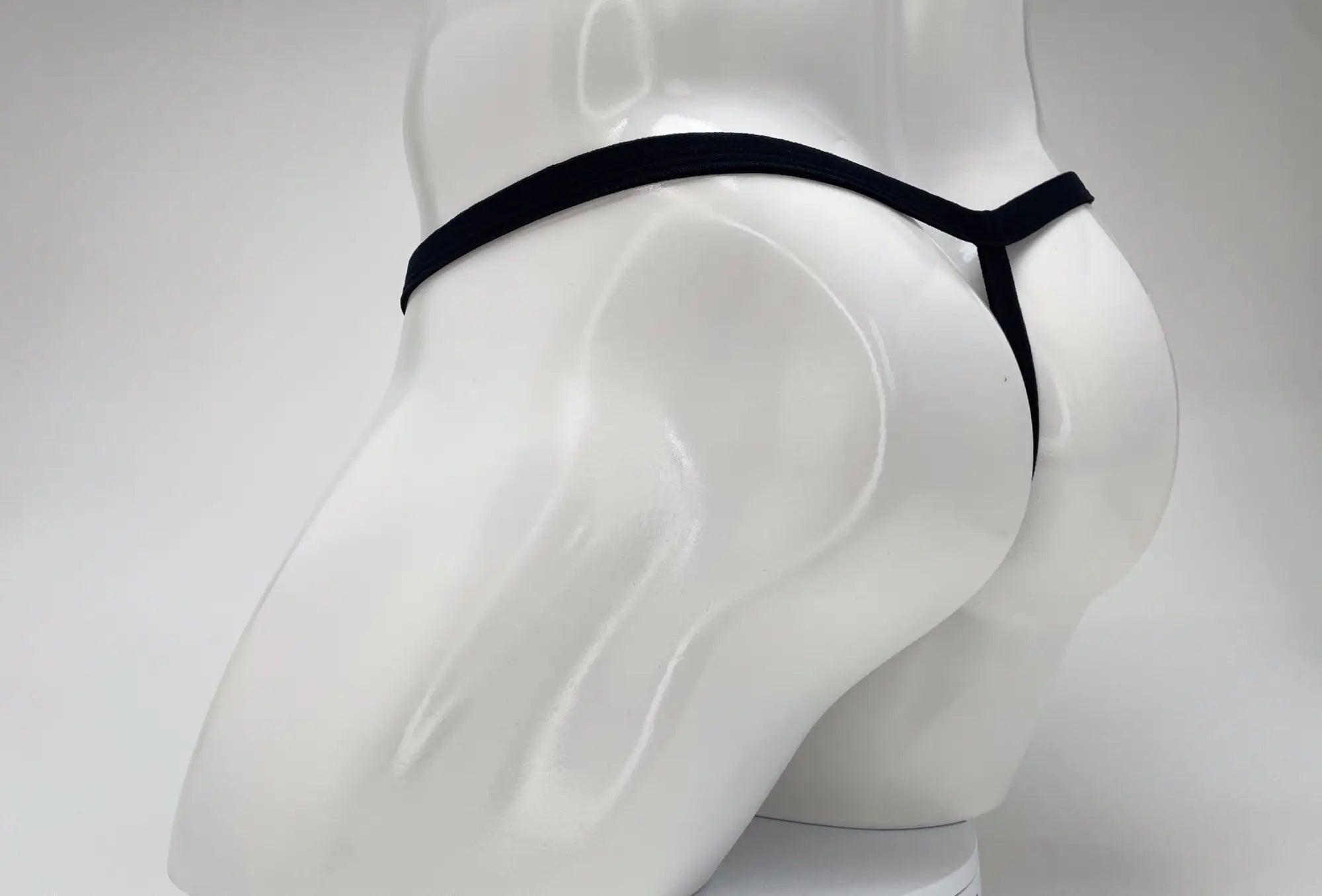 Wildmant modal micro thong big boy pouch in pink displayed on white mannequin showing black thong backside
