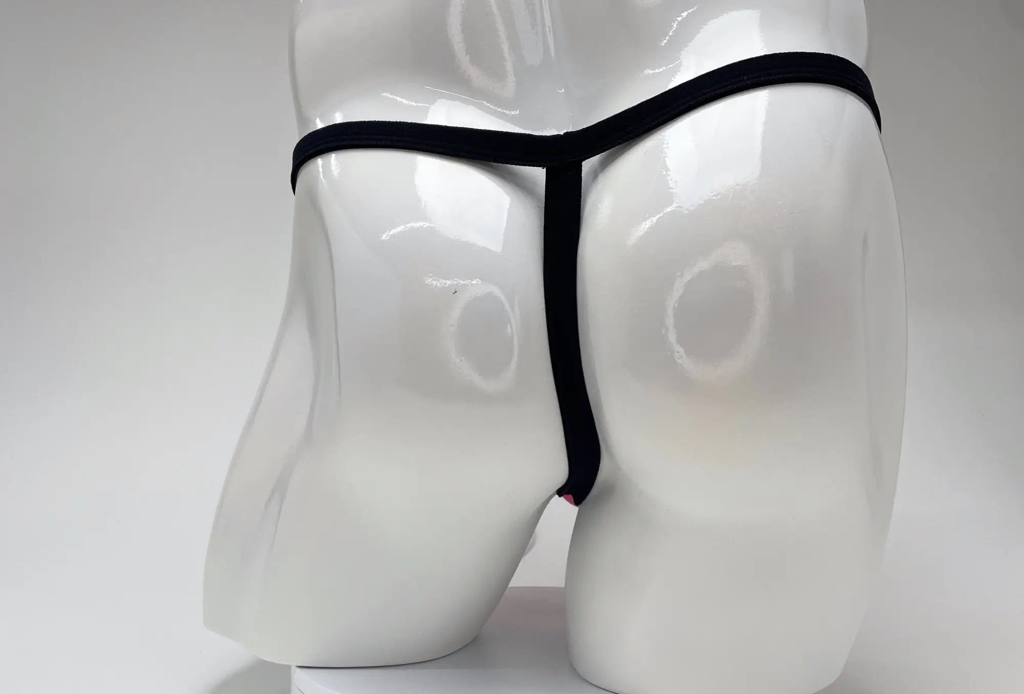 Black thong on white mannequin showing back side wildmant modal micro thong big boy pouch pink material