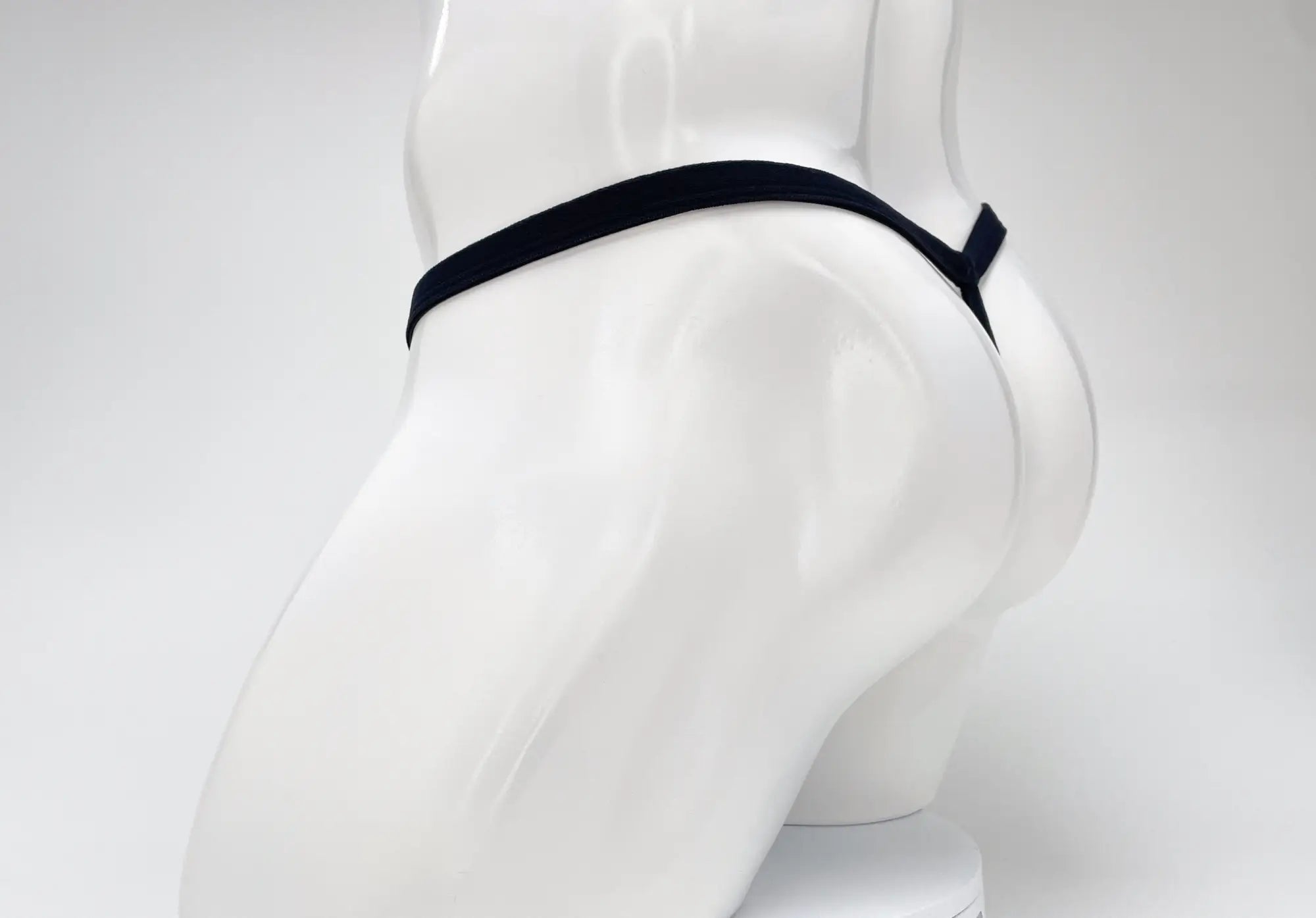 Black elastic waistband modal micro thong with big boy pouch in purple displayed on white mannequin
