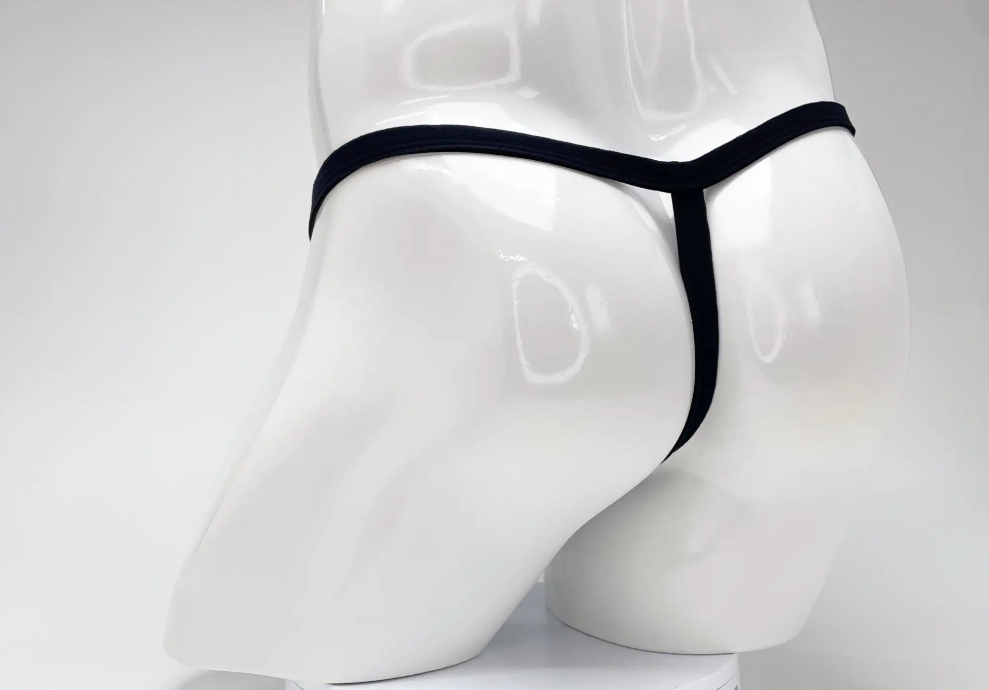 Black thong on white mannequin featuring wildmant modal micro thong big boy pouch in purple material
