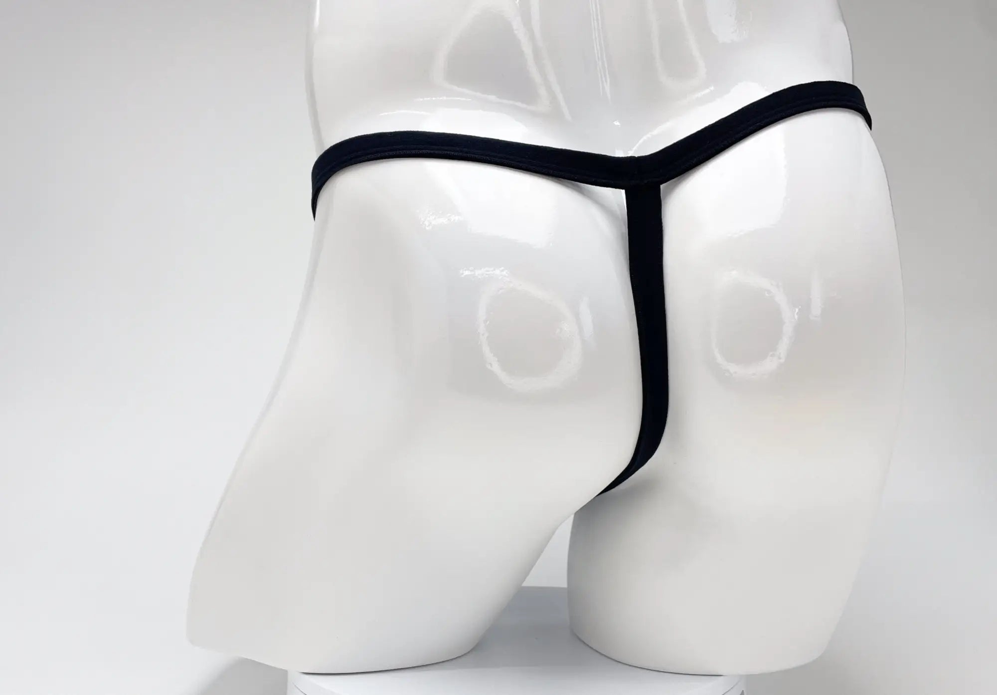 Black thong displayed on white mannequin wildmant modal micro thong big boy pouch purple fabric