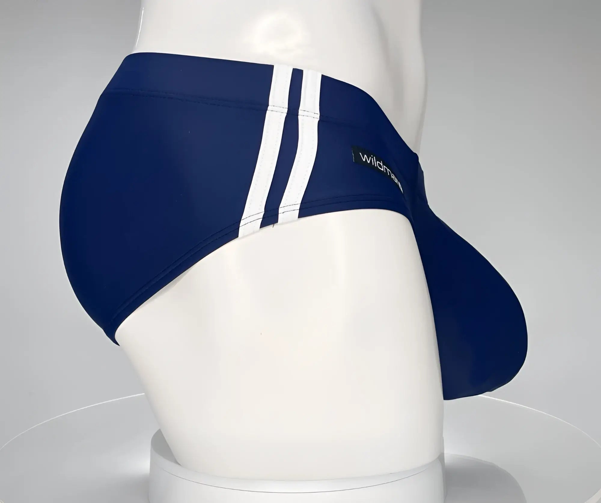 Navy blue WildmanT Monster Cock swim brief with three white vertical stripes and logo on the side