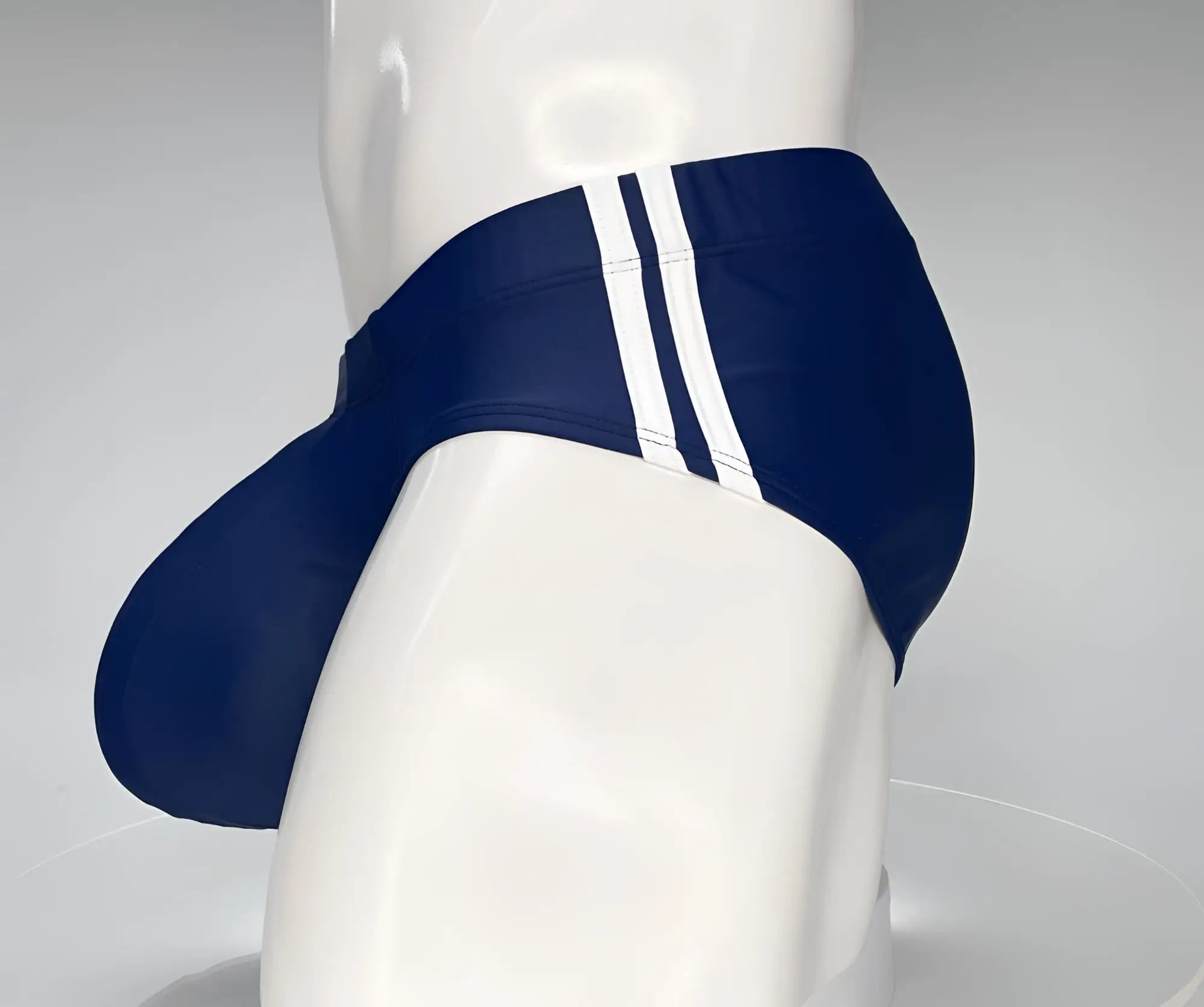 Navy blue WildmanT Monster Cock swim brief with three white side stripes displayed on a mannequin front view