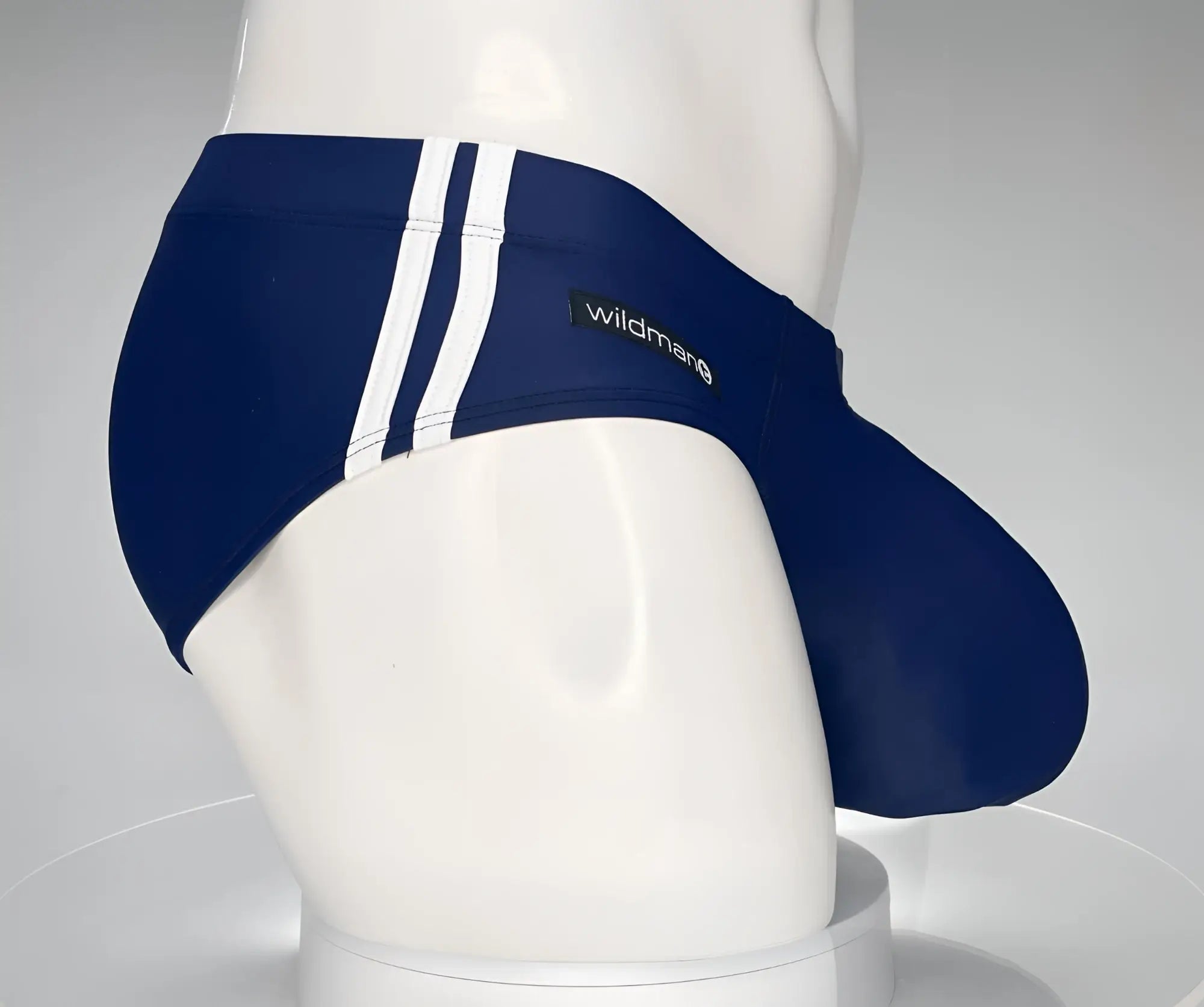 Navy blue WildmanT Monster Cock swim brief with white side stripes and branded label for swimming and beachwear