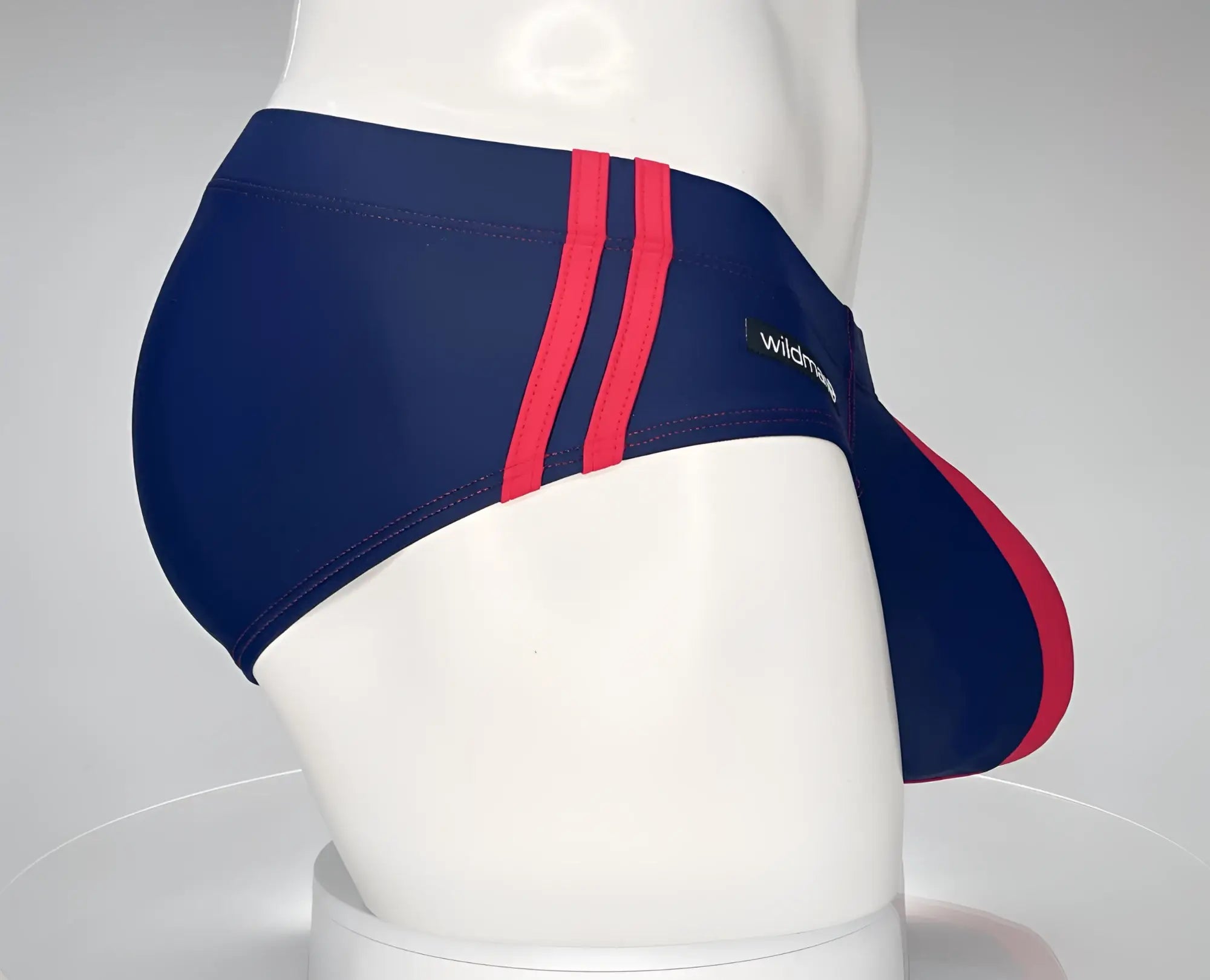 WildmanT monster cock swim brief navy red features sleek navy blue swim trunks with bold red stripes and form-fitting design