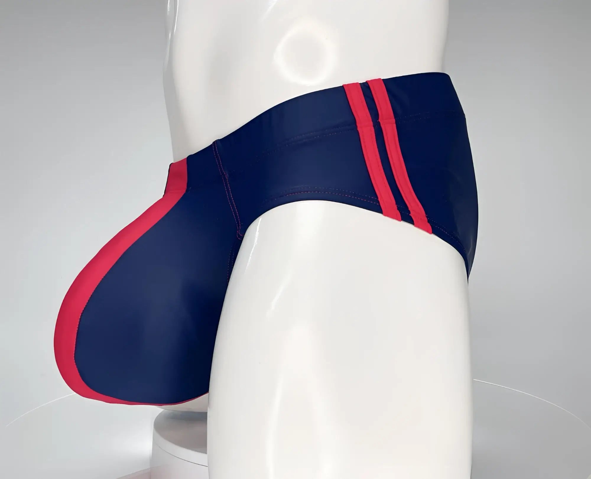 Navy blue WildmanT Monster Cock swim brief with bold red side stripes and matching red leg seam accent