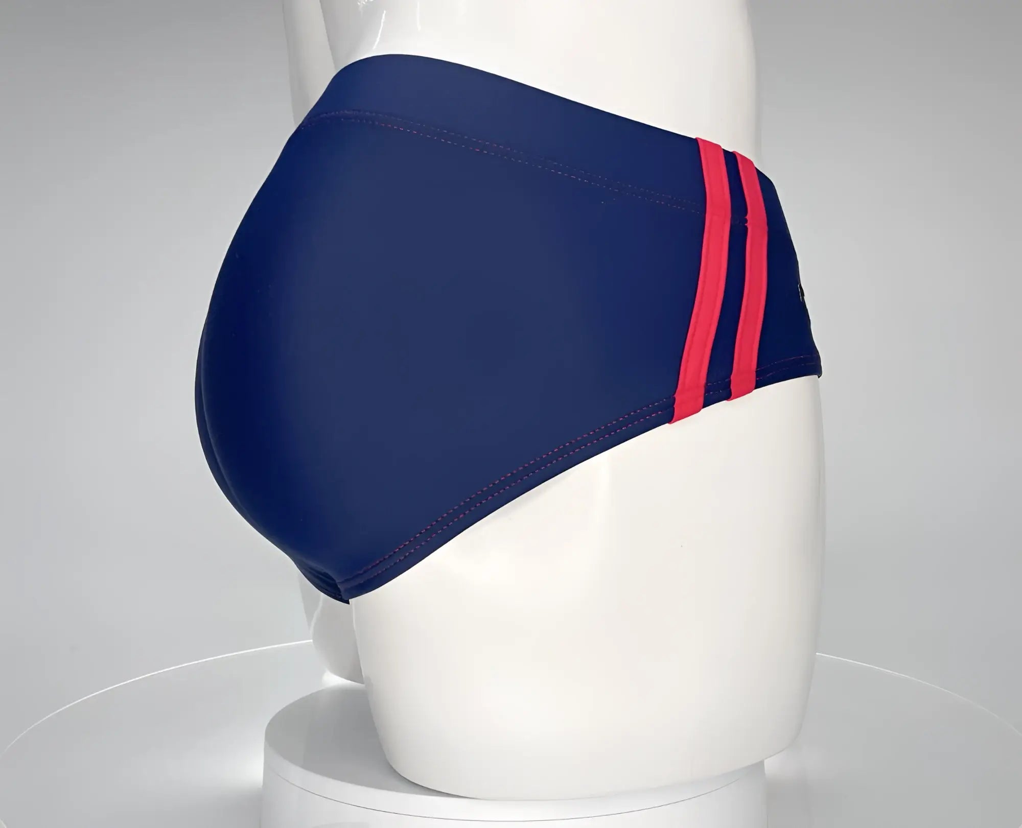 WildmanT monster cock swim brief in navy blue nylon with two bold red side stripes for swimming