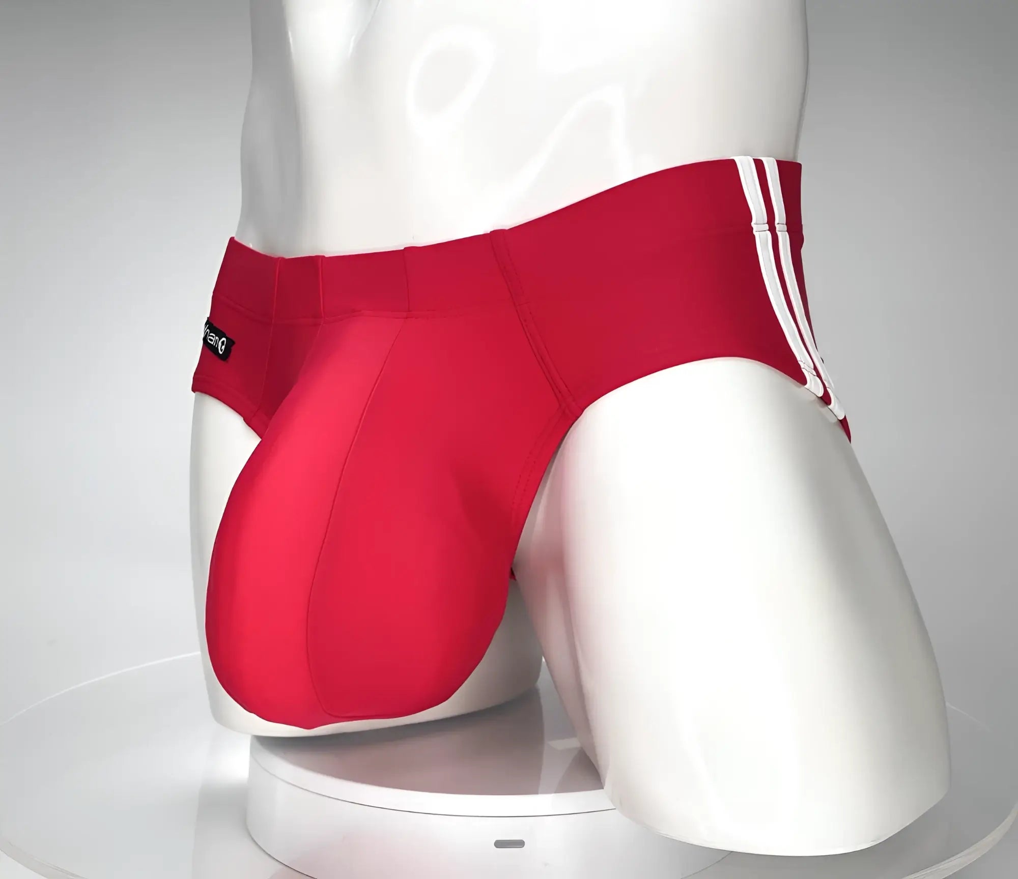 Wildmant monster cock swim brief red athletic briefs with white side stripes displayed on a mannequin