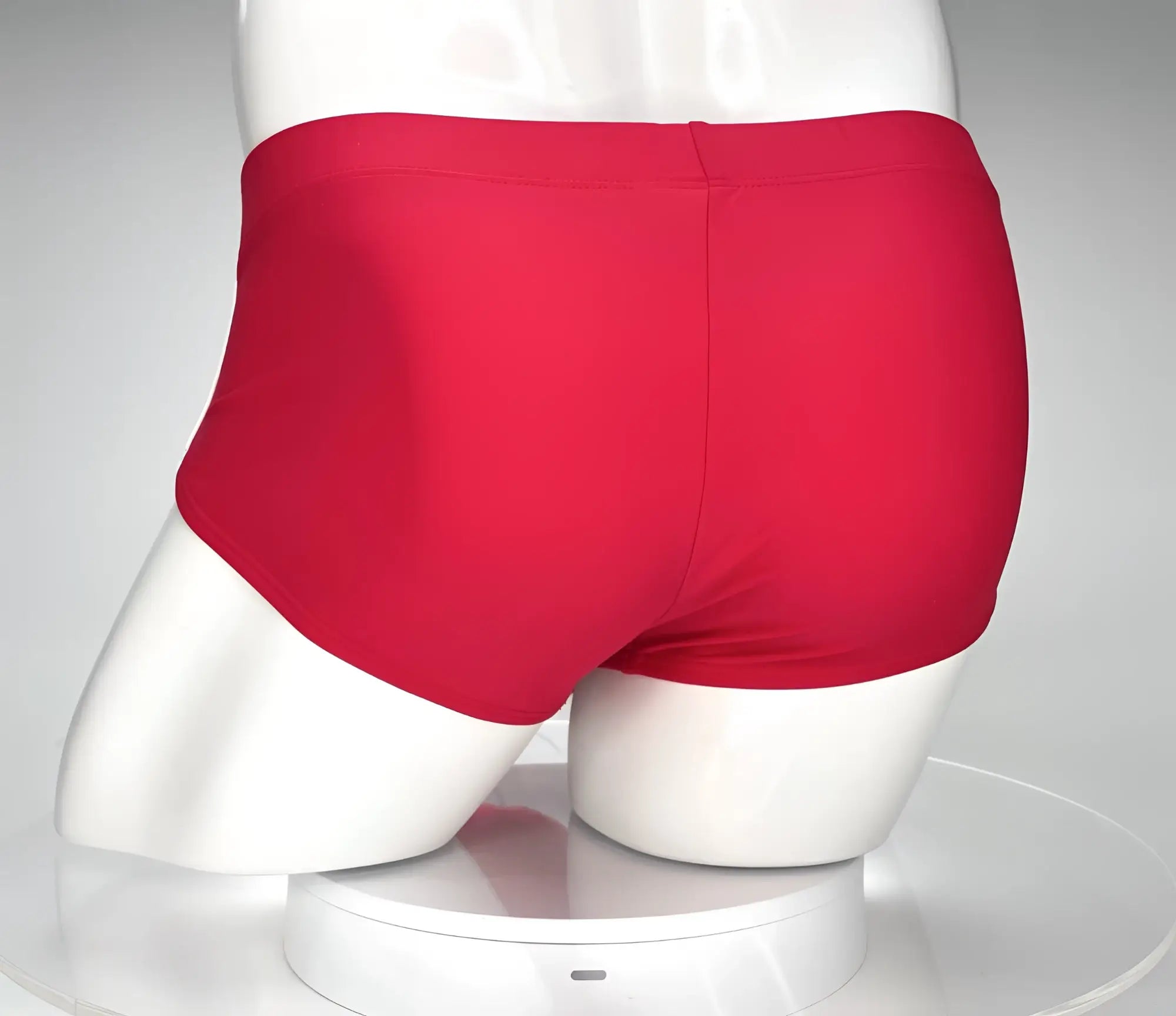 Bright red smooth textured swim briefs by WildmanT designed for comfortable swimwear use displayed on a mannequin