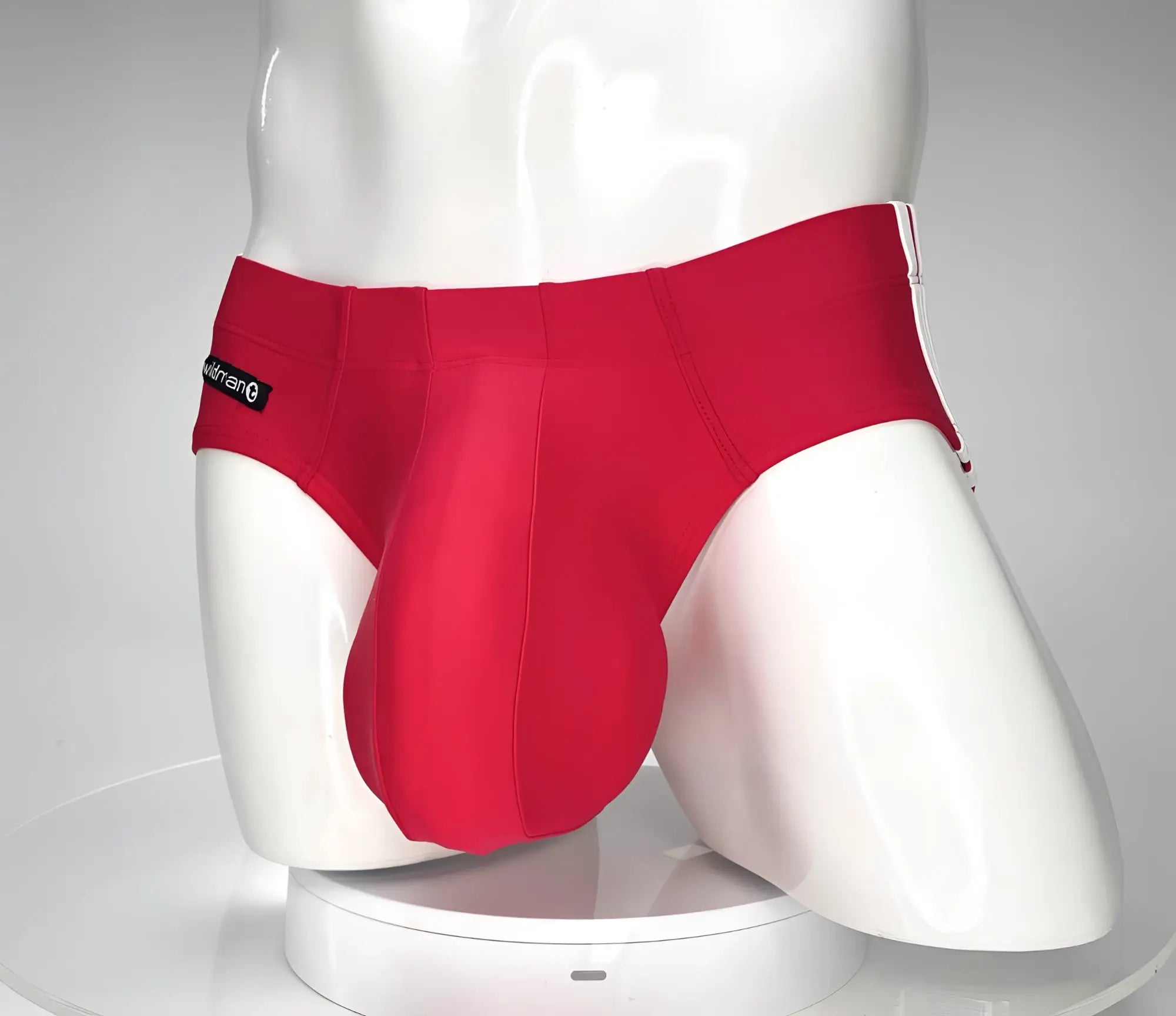 Red wildmant monster cock swim brief with white trim and black brand tag on waistband for men