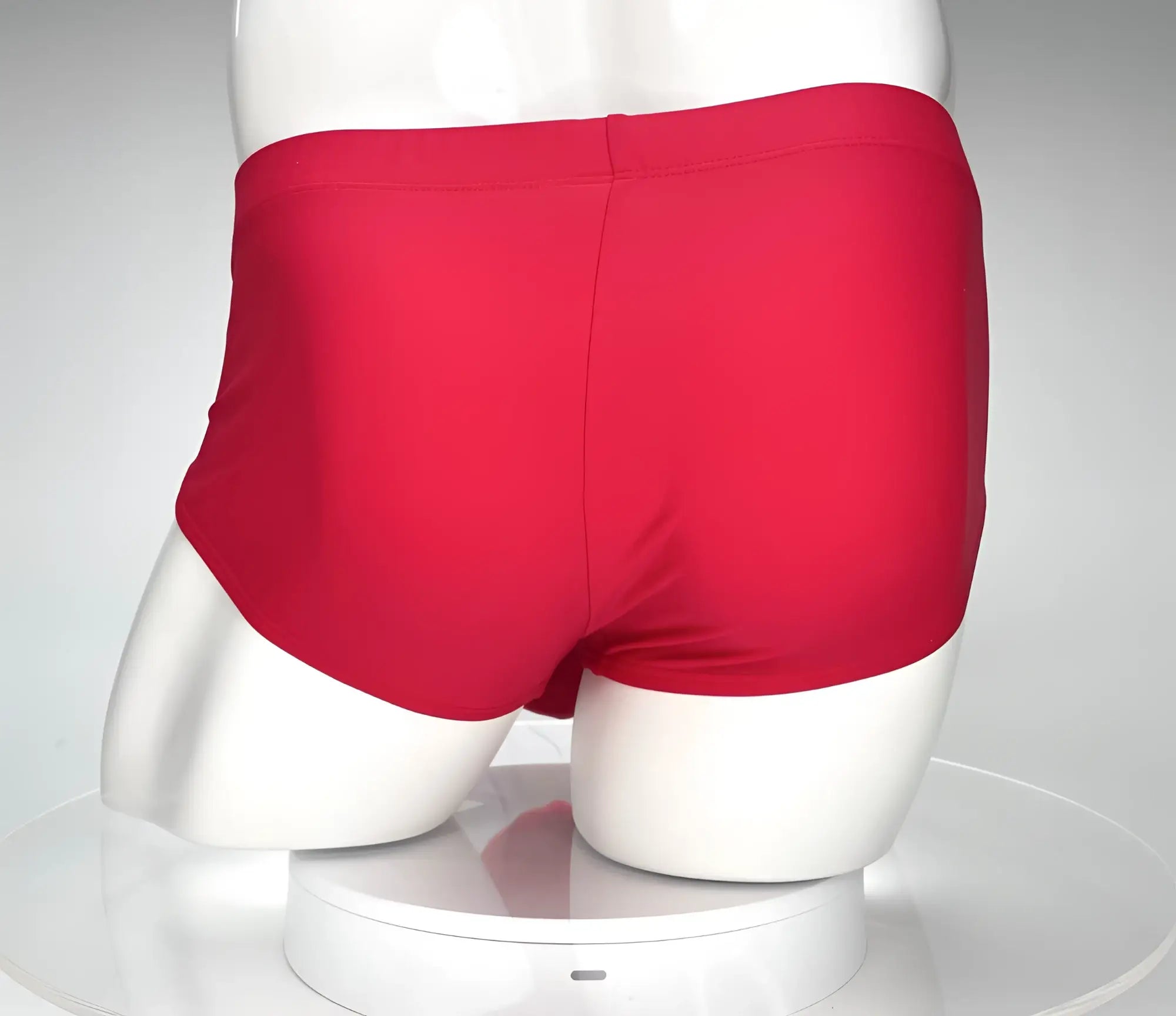 Red swim briefs by wildmant in a bold monster cock design displayed on a mannequin for swimwear use