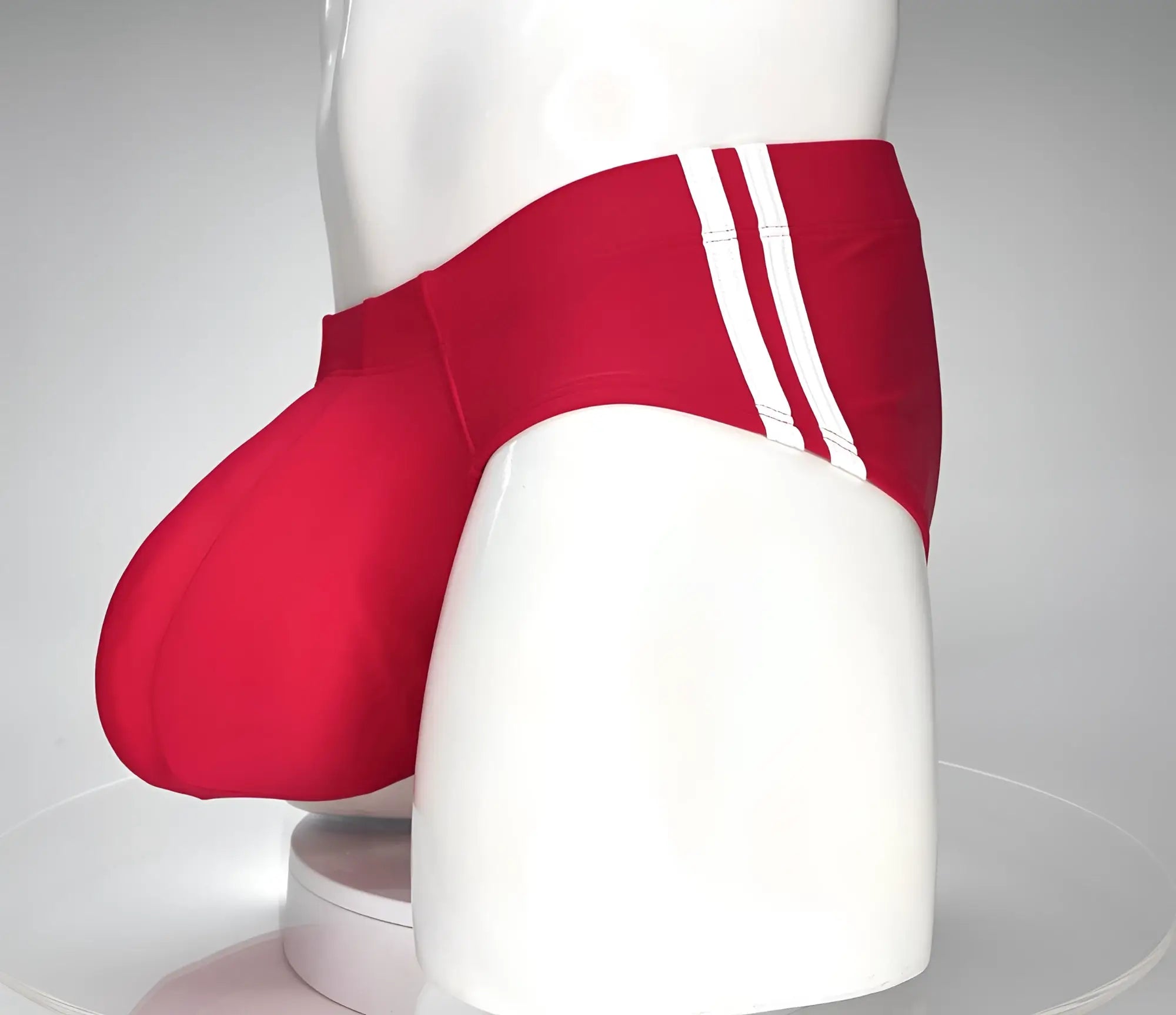 WildmanT monster cock swim brief red featuring red swim trunks with three white stripes and a sleek athletic design