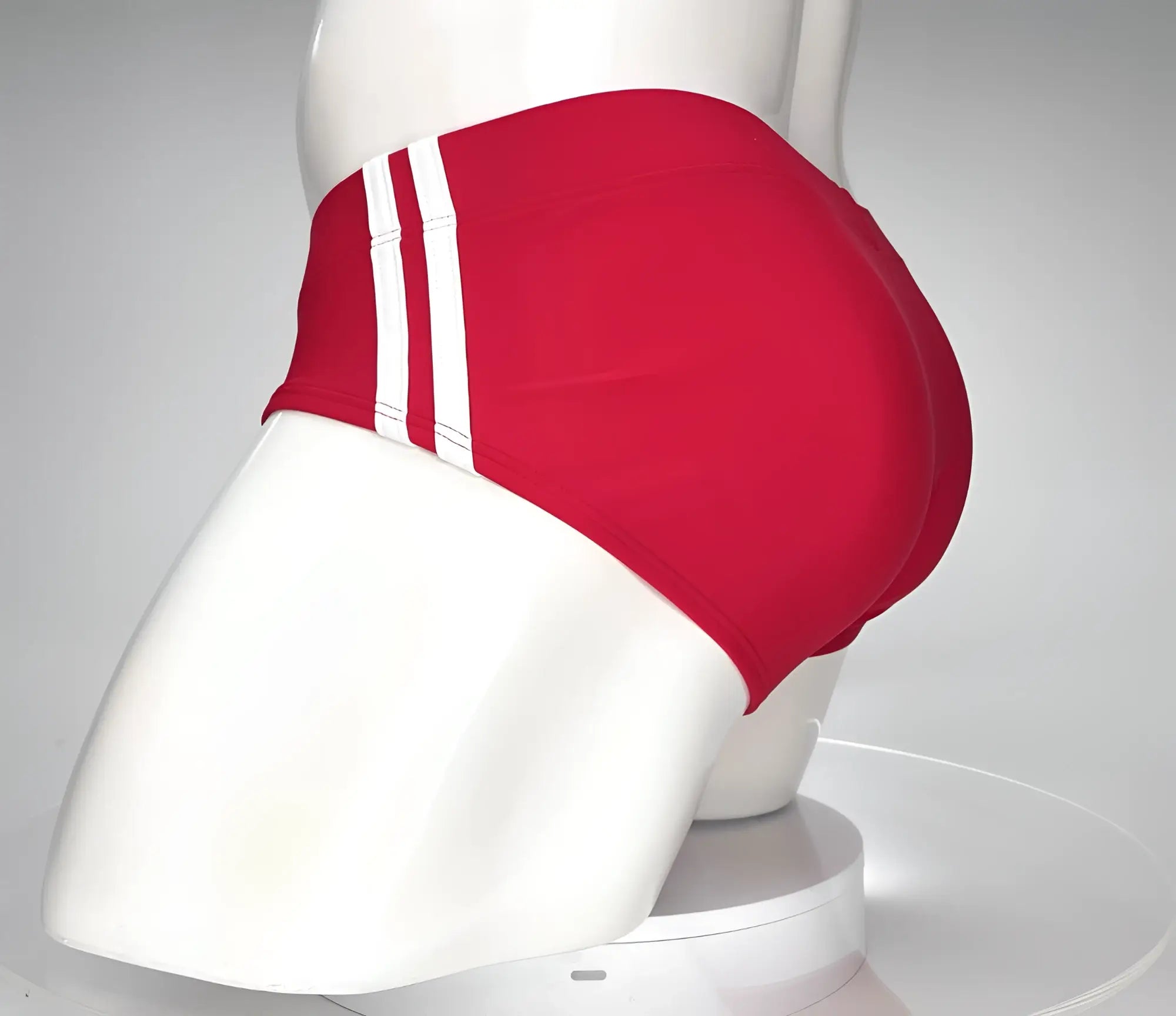 Wildmant monster cock swim brief red swim trunks with three white stripes on the side displayed on a mannequin
