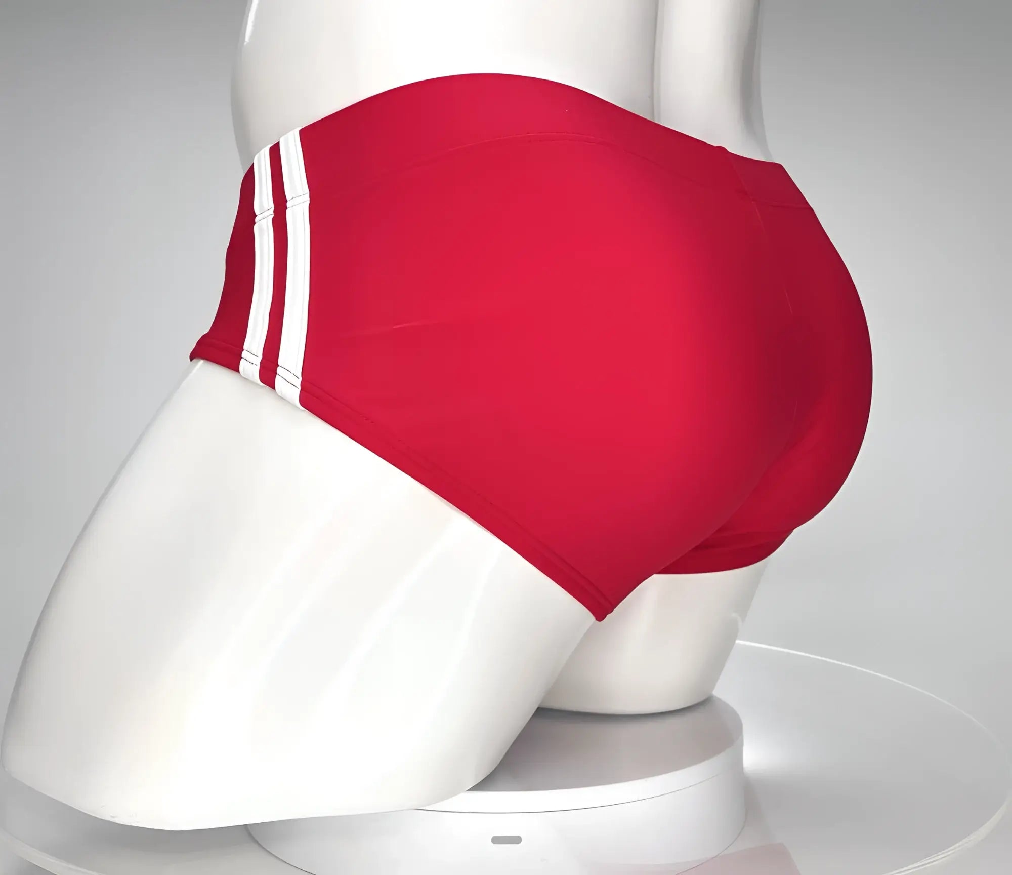 WildmanT monster cock swim brief red displayed on mannequin featuring red swim trunks with three white side stripes