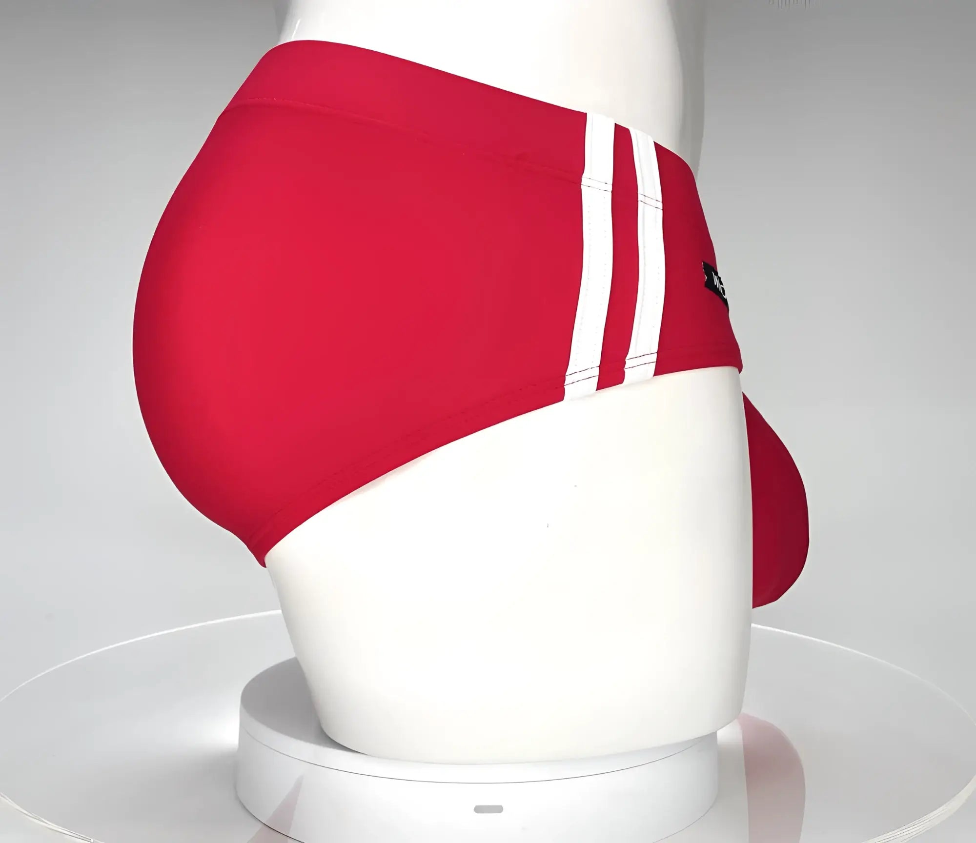 WildmanT monster cock swim brief red featuring red swim trunks with three white stripes and a black side logo