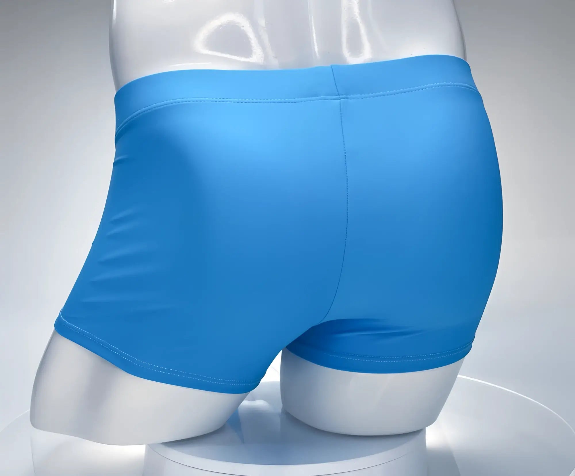 Bright blue smooth-fitting boxer briefs by wildmanT monster cock swim square cut in teal and white displayed on a mannequin
