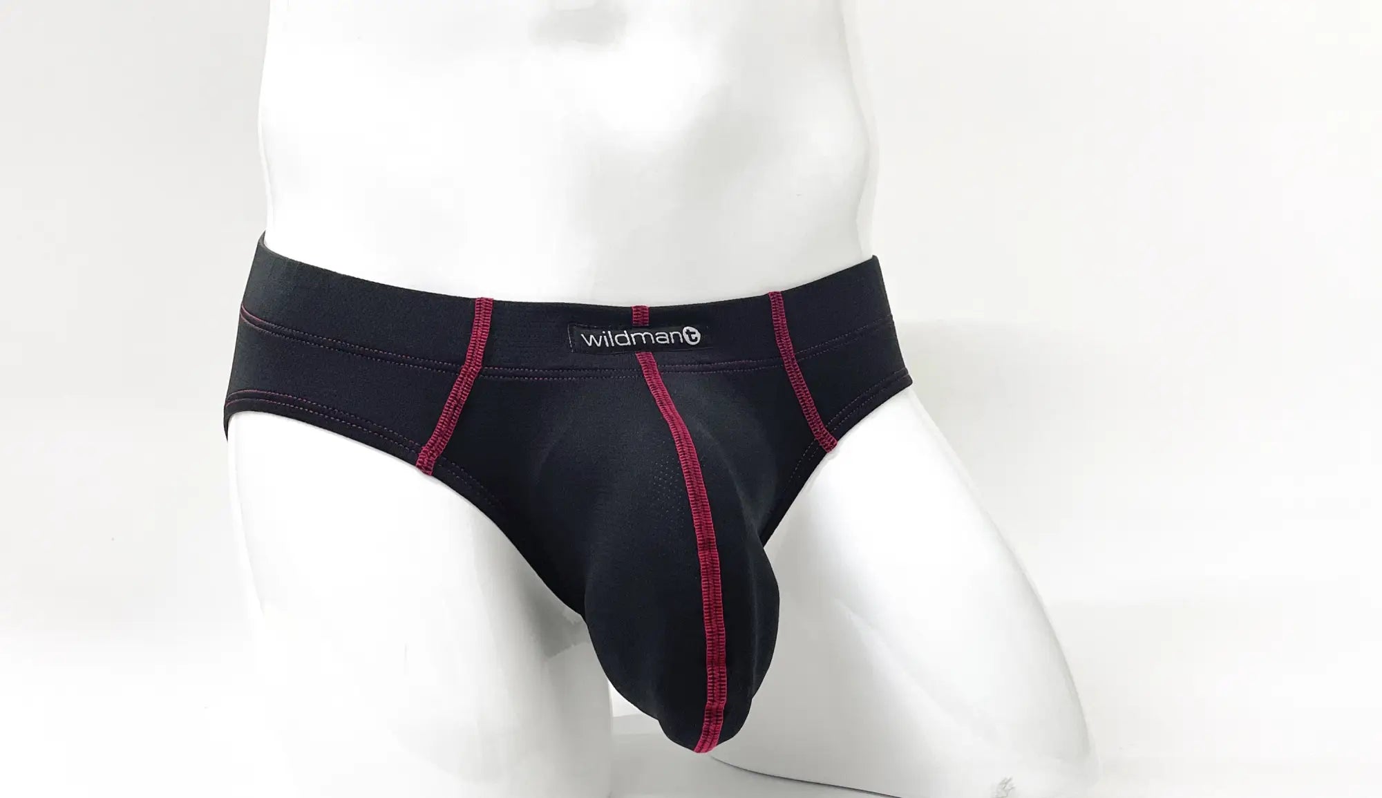 Black men’s briefs with red stitching and wildman brand label on waistband showing front pouch design