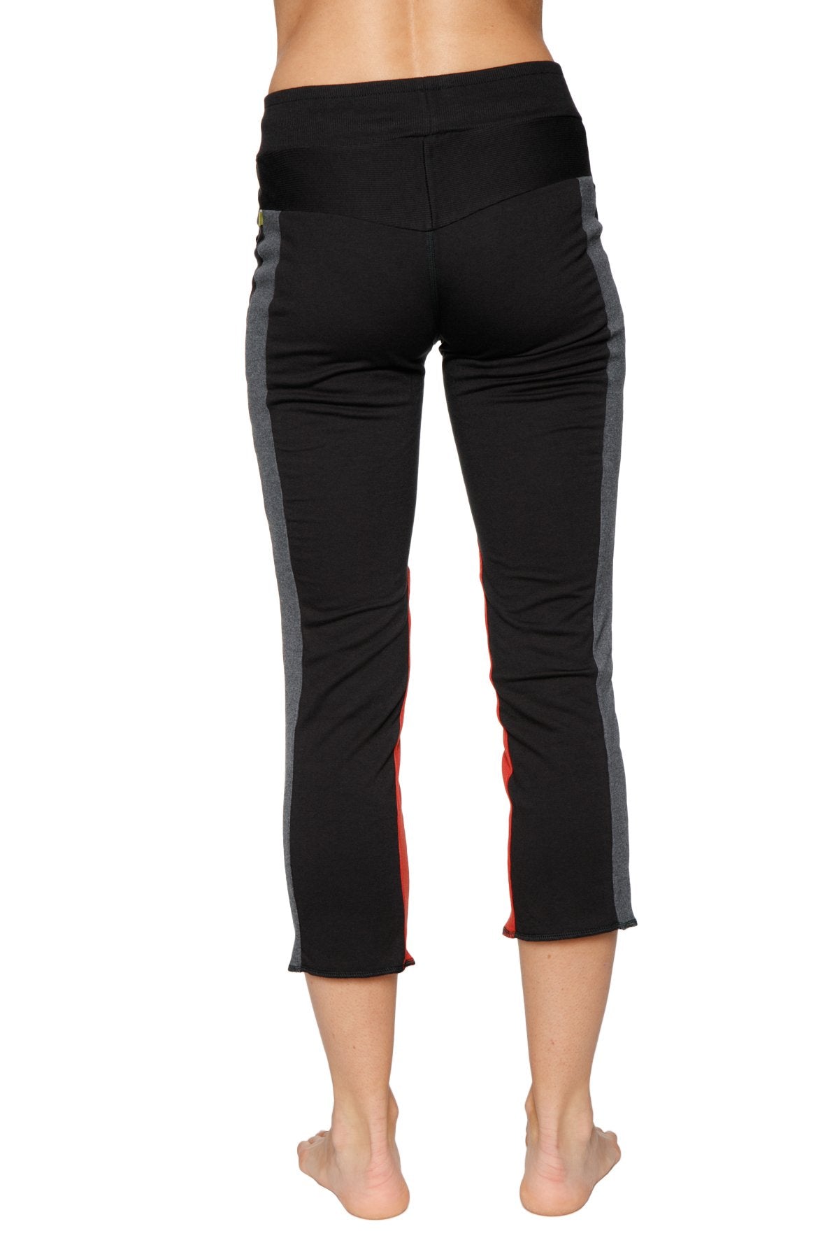 Women’s black capri-length yoga pants with gray and red side panels and zipper pocket for activewear