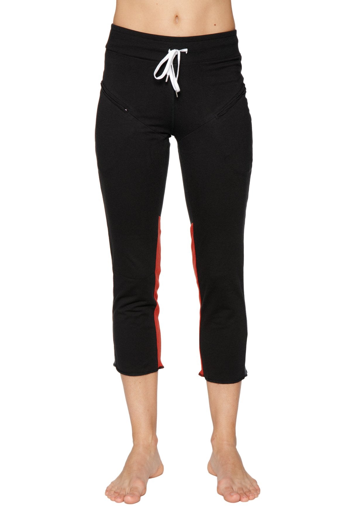 Women’s black capri yoga pants with red side stripes and white drawstring waistband featuring zipper pockets