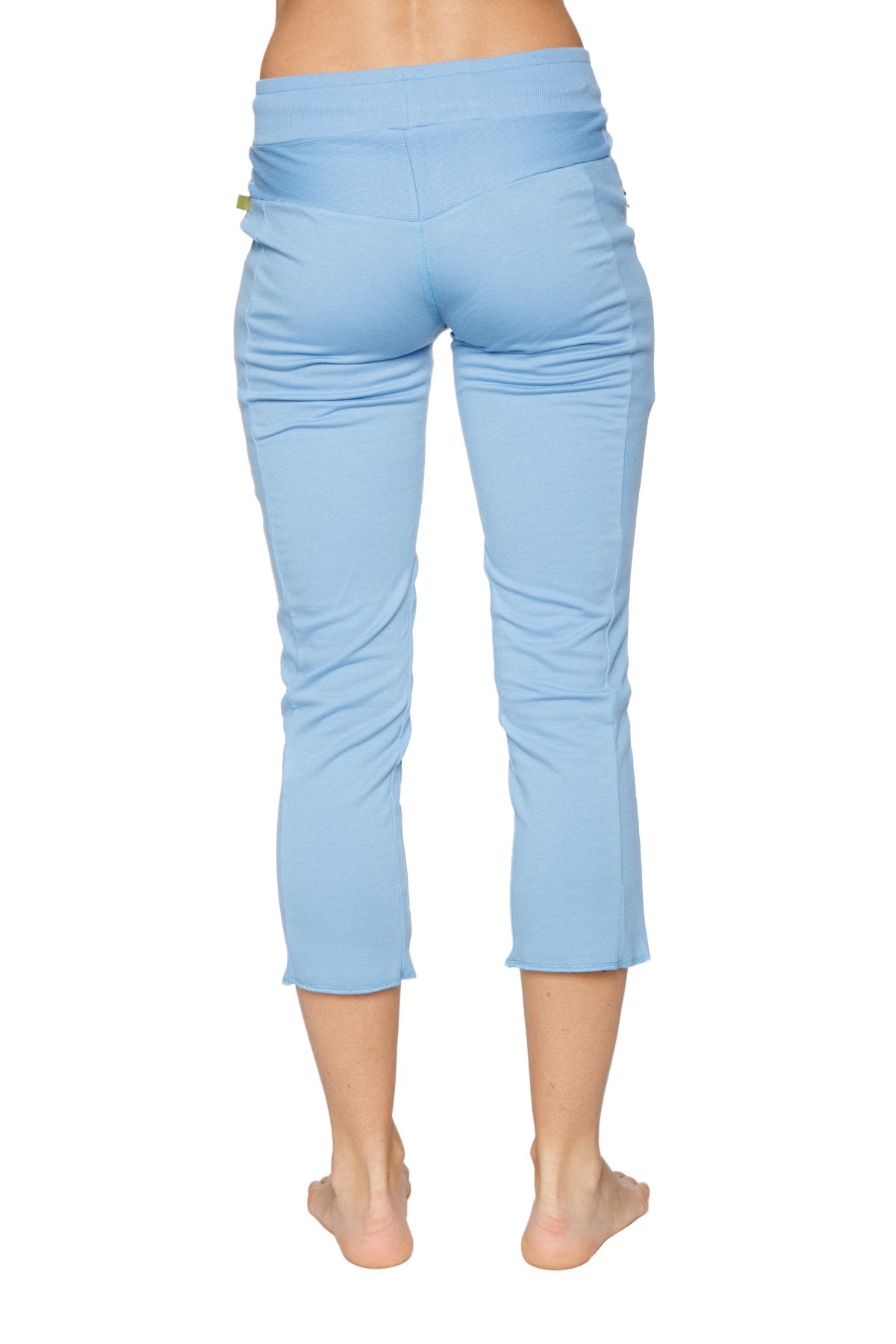 Women’s sky blue capri yoga pants with a high-waisted design, stretchy fabric, subtle side ruching, and zipper pockets