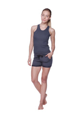 A woman models a charcoal women’s all-american racerback tank top with sleeveless design and matching shorts