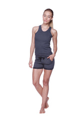 A woman models a charcoal women’s all-american racerback tank top with sleeveless design and matching shorts