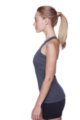A woman wearing a charcoal women’s all-american racerback tank top in dark gray with black shorts visible from the front