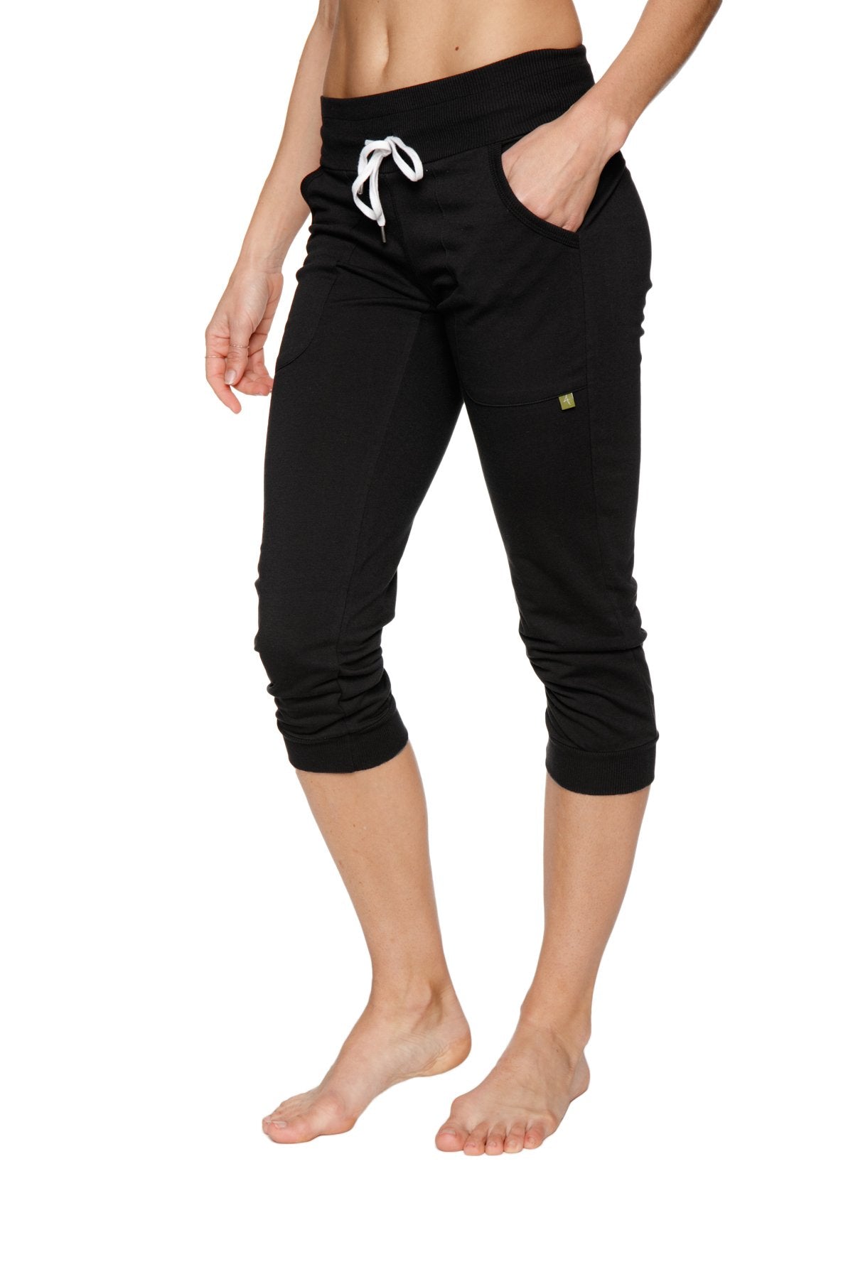 Women’s solid black cuffed jogger yoga pants with white drawstring waistband and side pockets in capri length