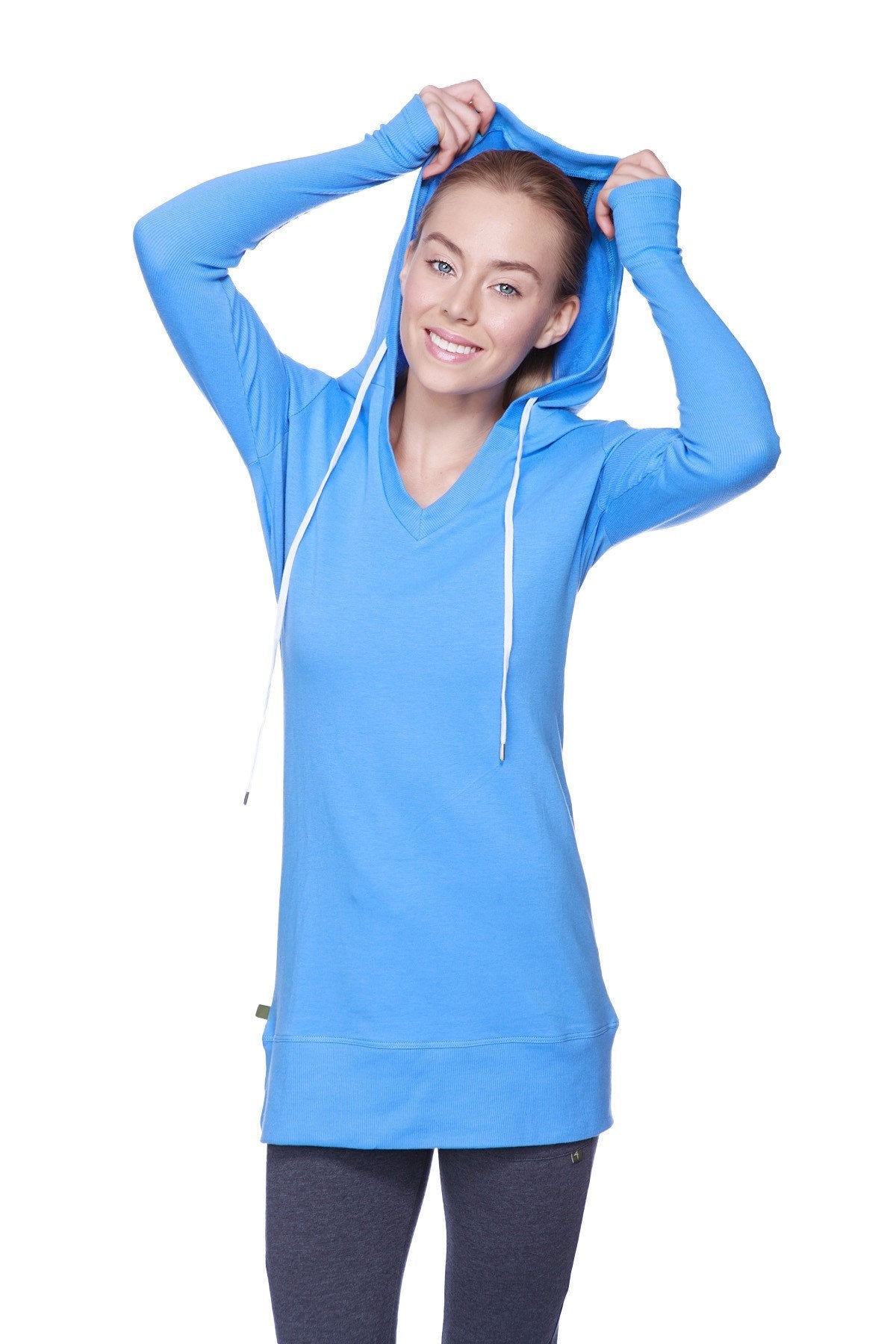 A vibrant ice blue women’s long body hoodie top with a v-neck, royal blue sleeves, and white drawstrings