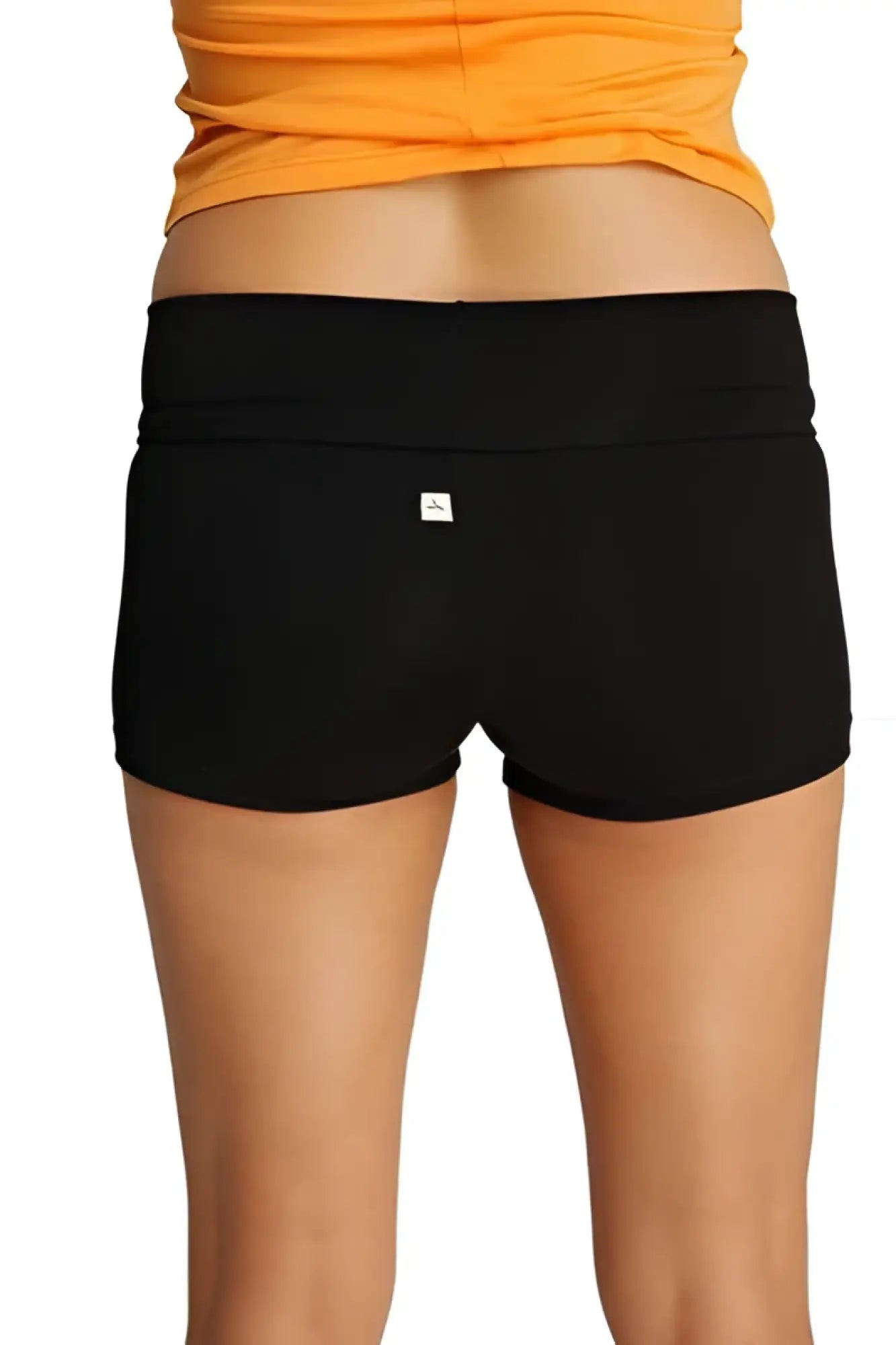 Back view of womens yoga transition shorts in black stretchy fabric with wide waistband and small white logo