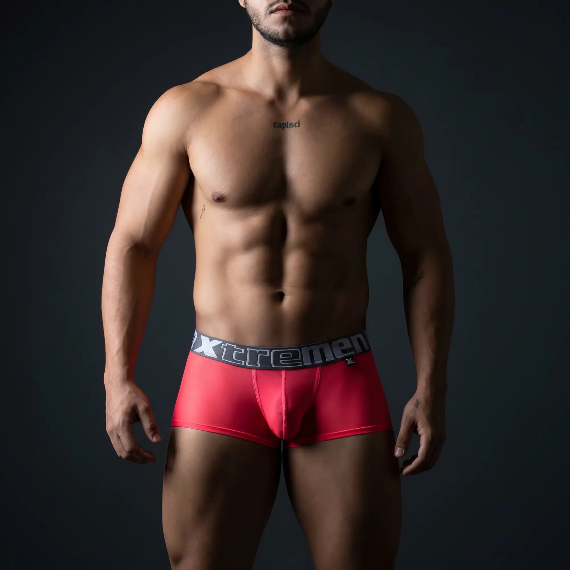 Athletic man in vibrant fuchsia Xtremen microfiber trunks with bold branded waistband, dramatic dark studio — Xtremen banner