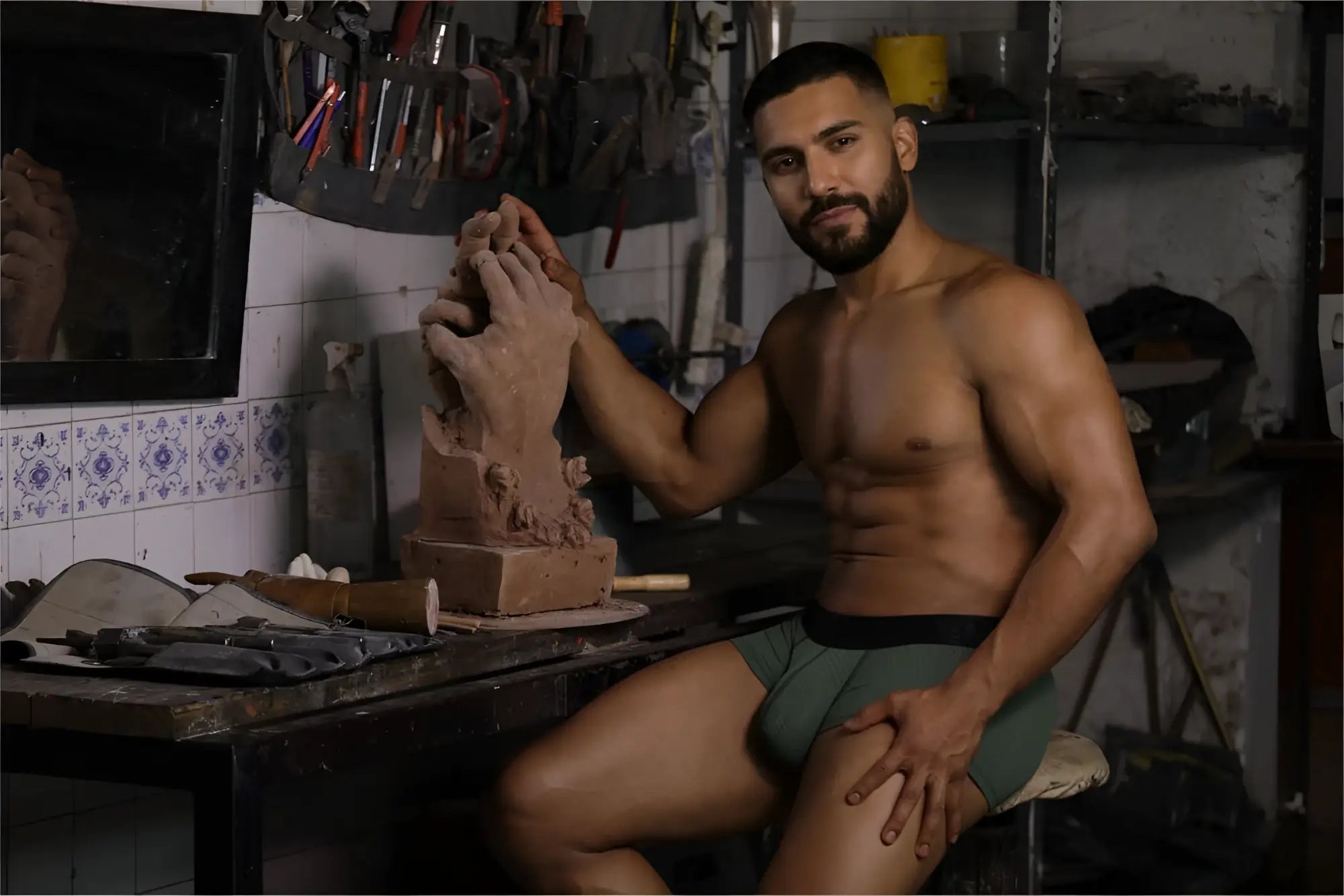 A clay sculpture hand being shaped by artist hands next to xtremen 91252 microfiber mesh trunks in military green