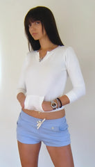 White long-sleeved henley top with cropped hem paired with baby blue yoga training shorts for fitness activities