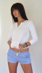 White long-sleeved henley top with cropped hem paired with baby blue yoga training shorts for fitness activities